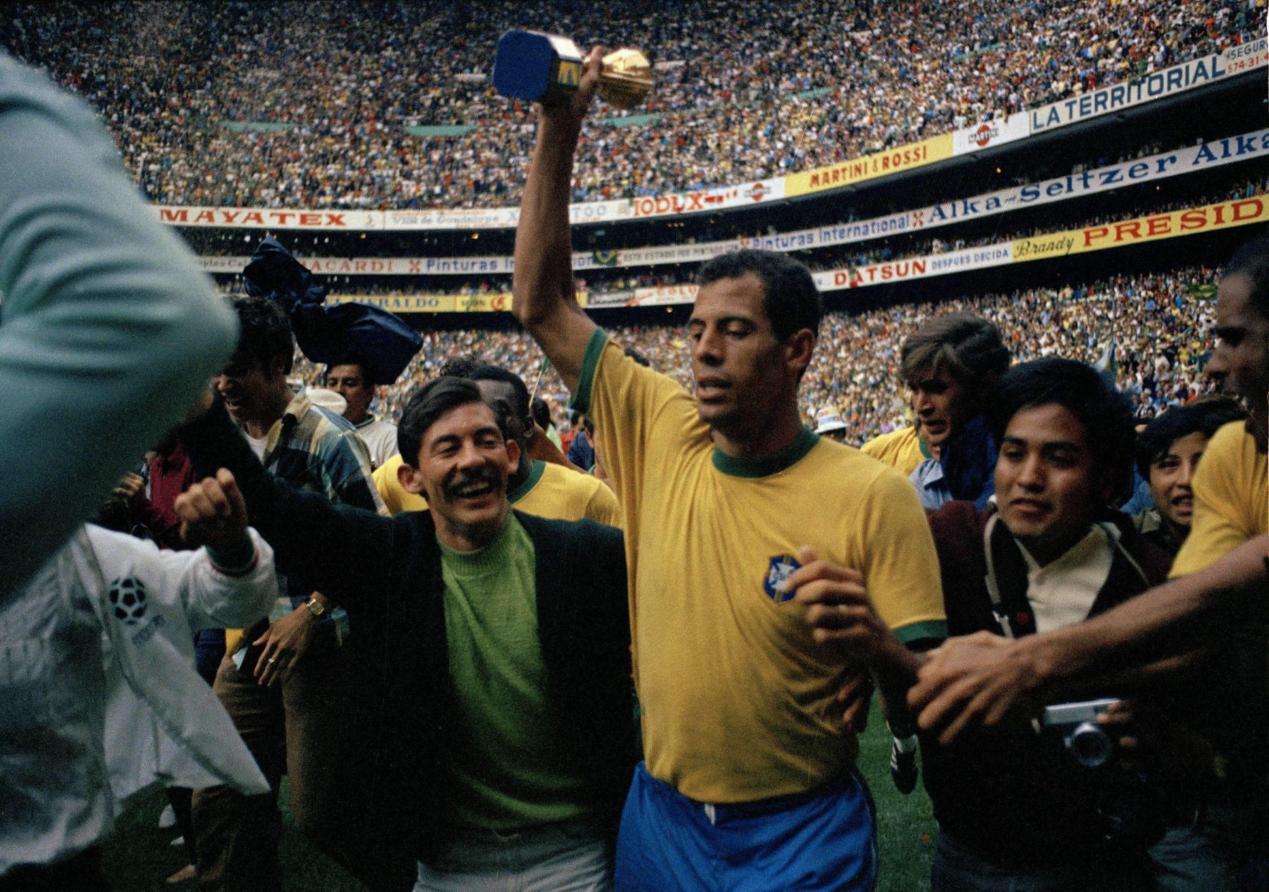 Pele celebrating with the FIFA World Cup trophy during Brazil's 1970 World Cup victory at a packed stadium
